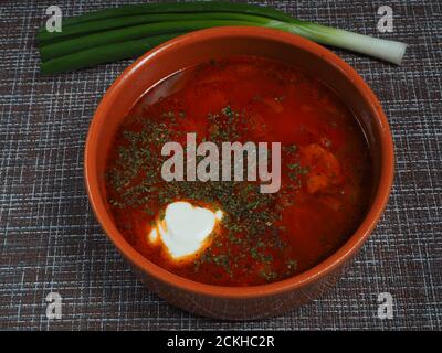 Red borscht with sour cream in a bowl. Stock Photo