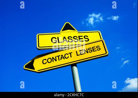Glasses versus contact lenses road sign with two arrows on blue sky ...