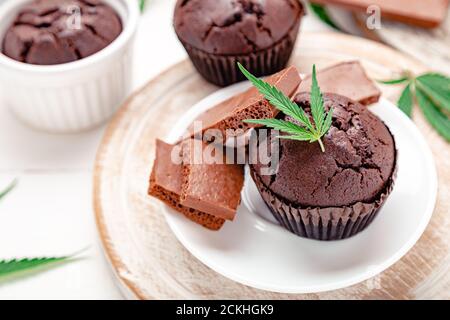 Marijuana chocolate cupcake muffins with weed cbd. Medical marijuana hemp drugs in food dessert. Weed muffins with cannabis, milk chocolate and Stock Photo