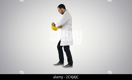 Young construction engineering student walking and putting cap o Stock Photo