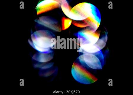 Lens flare, Bokeh lights. Reflections from glass, diamond, crystal. Defocused shining colorful rainbow light leaks, rays on black background Stock Photo