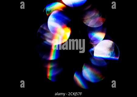 Lens flare, Bokeh lights. Reflections from glass, diamond, crystal. Defocused shining colorful rainbow light leaks, rays on black background Stock Photo