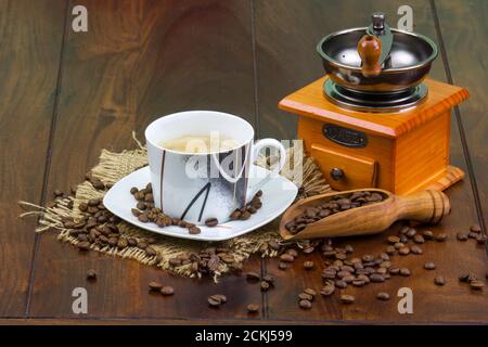 cup of coffee, coffee beans and old coffee grinder on the wooden background Stock Photo