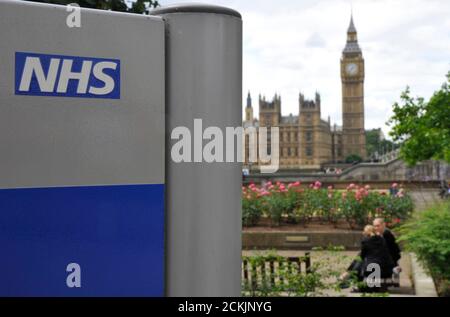 A National Health Service (NHS) sign is seen in the grounds of St Thomas' Hospital, in front of the Houses of Parliament in London June 7, 2011. Reforms to Britain's cherished state-funded health service will not result in a U.S.-style private system, Prime Minister David Cameron said on Tuesday, seeking to win over wary Britons.    REUTERS/Toby Melville (BRITAIN - Tags: POLITICS HEALTH)