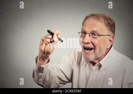 Portrait senior excited happy man writing something with pen on blackboard. Education concept Stock Photo