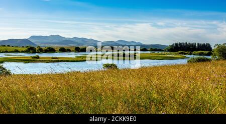 Brion village. Lake of Bordes on the Cezallier plateau in the Auvergne volcanoes regional natural park. Behind Massif of Sancy Stock Photo