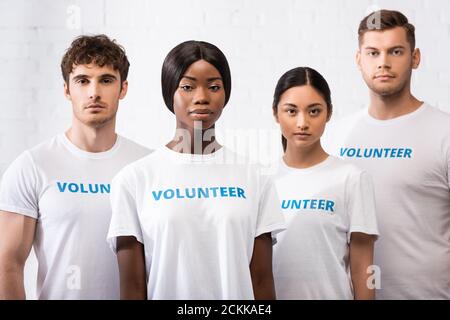 Selective focus of african american woman looking at camera near multiethnic volunteers Stock Photo
