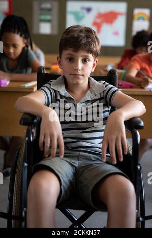 Portrait of disable boy sitting in his wheelchair in class at school Stock Photo