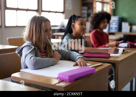 Group of kids sitting on their desk in the class at school Stock Photo