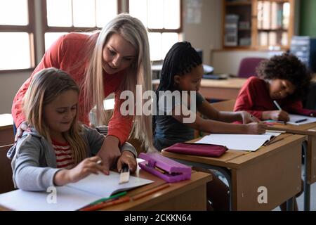 Female teacher teaching a girl in the class at school Stock Photo