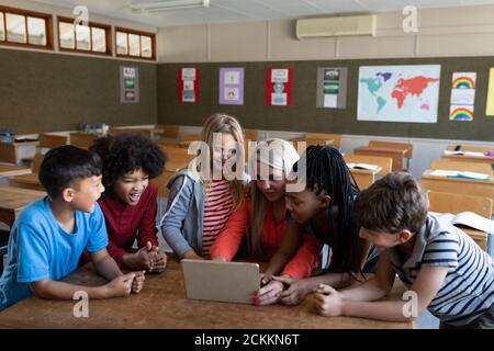 Female teacher and Group of kids using laptop in the class Stock Photo