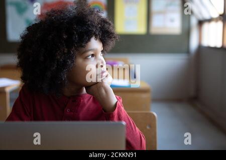 Boy sitting with laptop on his desk at school Stock Photo