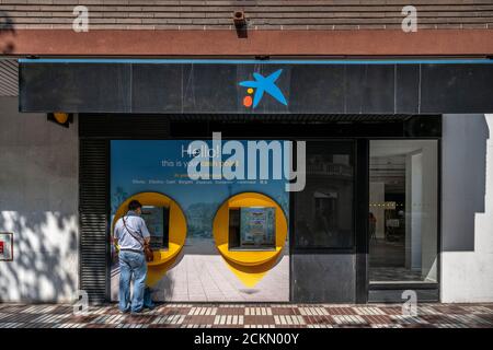 Barcelona, Spain. 16th Sep, 2020. A man is seen transacting at a Caixabank ATM machine.The boards of directors of the Spanish banking entities Caixabank and Bankia will approve the merger of the two entities into a new bank that will become the first Spanish bank in asset classification. Credit: SOPA Images Limited/Alamy Live News Stock Photo