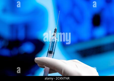 Doctor Hand in White Gloves Holding Syringe With Vaccine Before Immunization and Vaccination. Medical Trial of Medicine From SARS Coronavirus, 2019-nC Stock Photo