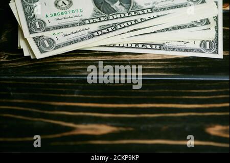stack of one dollar bills on a wooden background with copy space Stock Photo