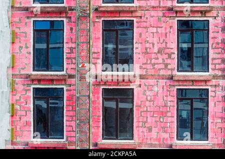 Windows of a house under construction from cinder blocks painted red Stock Photo