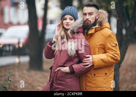 A cheerful guy and a girl are walking in the autumn park Stock Photo