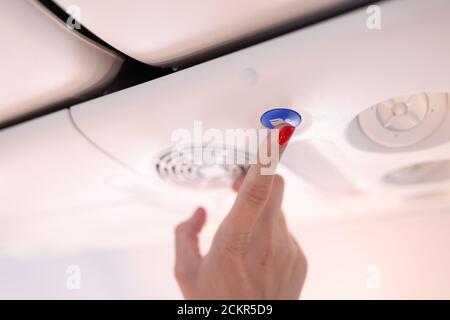 Female hand press blue button on plane. Stock Photo