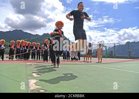 (200915) -- LINGYUN, Sept. 15, 2020 (Xinhua) -- Shen Yequan (Front) and students jump rope in Lanjin Primary School in Sicheng Township of Lingyun County, south China's Guangxi Zhuang Autonomous Region, Sept. 8, 2020. Shen, 28, is the only PE teacher of the village school. He was assigned to teach physical education in the school in 2018 after graduating with a bachelor degree in sports. 'Because of our unrelenting efforts, children have a strong desire for physical activities. I will stick at my post here to help rural children cultivate the habit of taking part in sports from an early age, Stock Photo