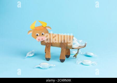 bull or ox made by kids from toilet paper roll, tutorial, DIY, step by step instruction, original packaging for sweets, simple craft for new year Stock Photo
