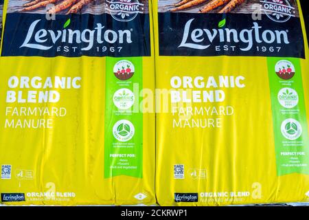 A stack of bags of Organic Farmyard Manure  improving soil quality and promoting plant growth  for sale  in a farm shop Stock Photo