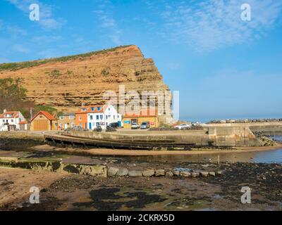 Behind the Cod and Lobster pub on the harbour front at Staithes North Yorkshire in high summer a view of Cowbar nab cottages and the lifeboat station Stock Photo