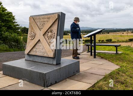 A man wearing a face mask reads the battle trail information board, Battle of Pinkie Cleugh memorial, East Lothian, Scotland, UK Stock Photo