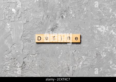 Define word written on wood block. Define text on cement table for your desing, concept. Stock Photo