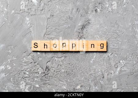 shopping word written on wood block. shopping text on cement table for your desing, concept. Stock Photo