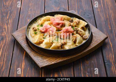 Pan with fried meat dumplings with bacon and mushroom sauce Stock Photo