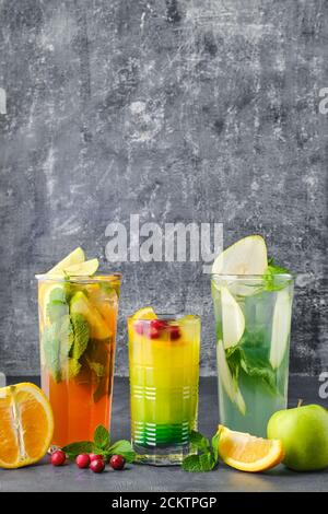 Three glasses with fruit refreshing drink on gray shabby background Stock Photo