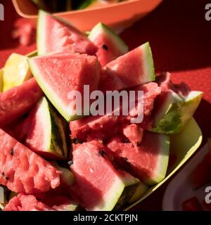 Sliced ripe pieces of watermelon in a bowl at a picnic outside. Square frame Stock Photo