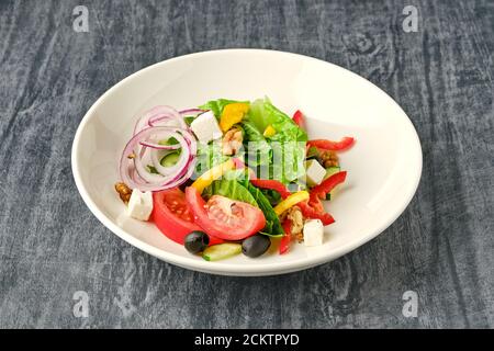 Plate of salad with vegetables, feta cheese, and walnuts Stock Photo