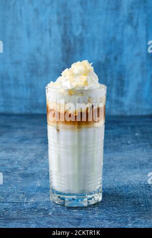 Tall glass of milkshake with whipped cream and peanut flakes Stock Photo
