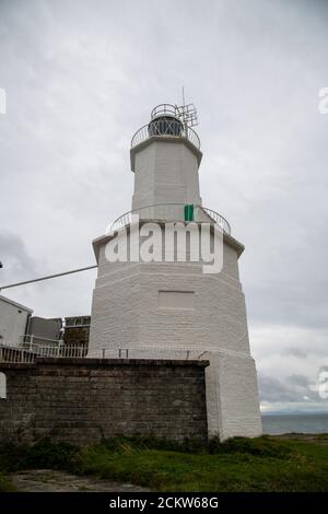 Offshore island with lighthouse on Mumbles Head in Swansea Bay Stock Photo