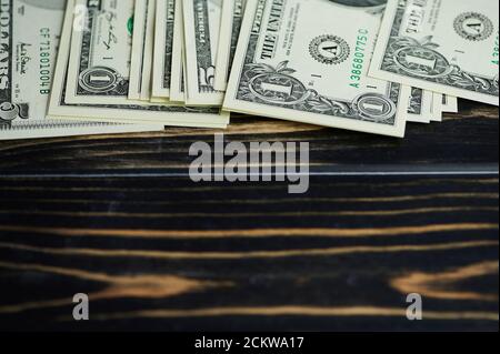 one and five dollar bills lying on wooden background with copy space Stock Photo