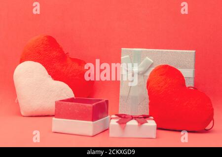 Valentine's day background with red and pink hearts, gift boxes on red background. Stock Photo