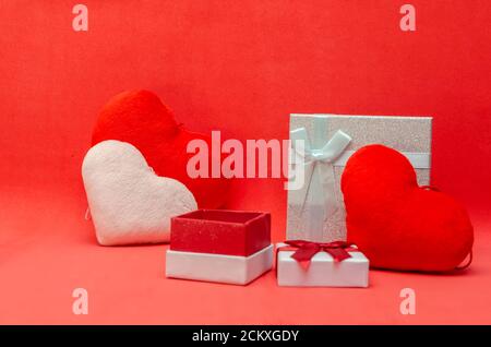Valentine's day background with red and pink hearts, gift boxes on red background. Stock Photo