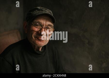 Pensive old man in glasses with gray hair Stock Photo