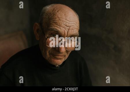 Pensive old man in glasses with gray hair Stock Photo