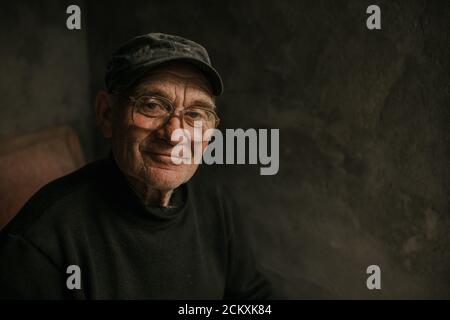 Pensive old man in glasses with gray hair Stock Photo