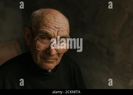 Pensive old man in glasses with gray hair Stock Photo