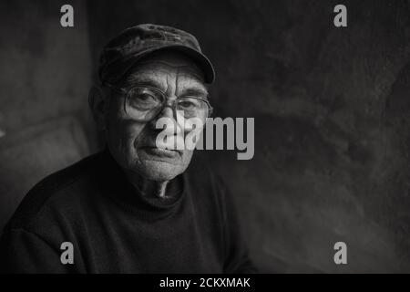 Pensive old man in glasses with gray hair Stock Photo