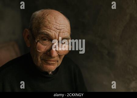 Pensive old man in glasses with gray hair Stock Photo