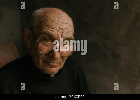 Pensive old man in glasses with gray hair Stock Photo