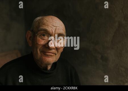 Pensive old man in glasses with gray hair Stock Photo