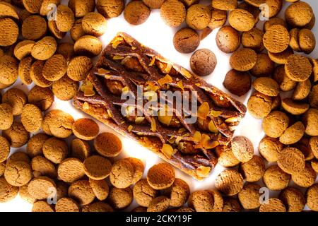 A Gevulde Speculoos lie next to a Dutch traditional candy called 'Pepernoten' on a white background, Pepernoten is a candy for the Dutch fest Sinterkl Stock Photo