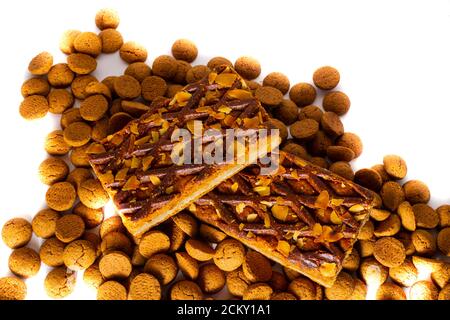 A Gevulde Speculoos lie next to a Dutch traditional candy called 'Pepernoten' on a white background, Pepernoten is a candy for the Dutch fest Sinterkl Stock Photo
