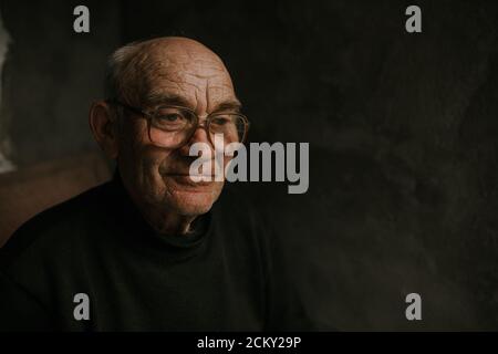 Pensive old man in glasses with gray hair Stock Photo