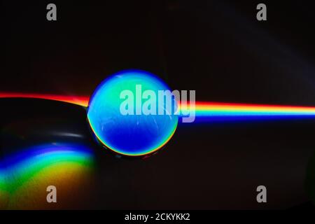 Colors of the rainbow product of Broken light, showing the spectrum of the light being bent by a spherical glass object physics and optics Stock Photo